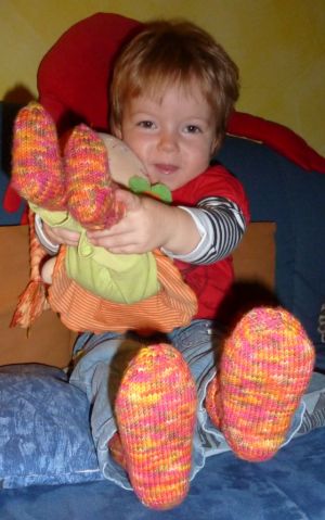 Sia zeigt stolz, dass Puppi auch so Socken hat wie sie.